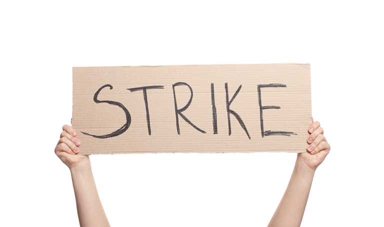 Kaksi kättä pitelee pahvikylttiä, jossa lukee