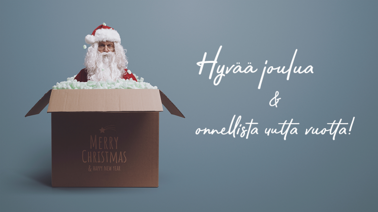 Joulupukki kurkistaa auki olevasta pahvilaatikosta, jonka kyljessä lukee