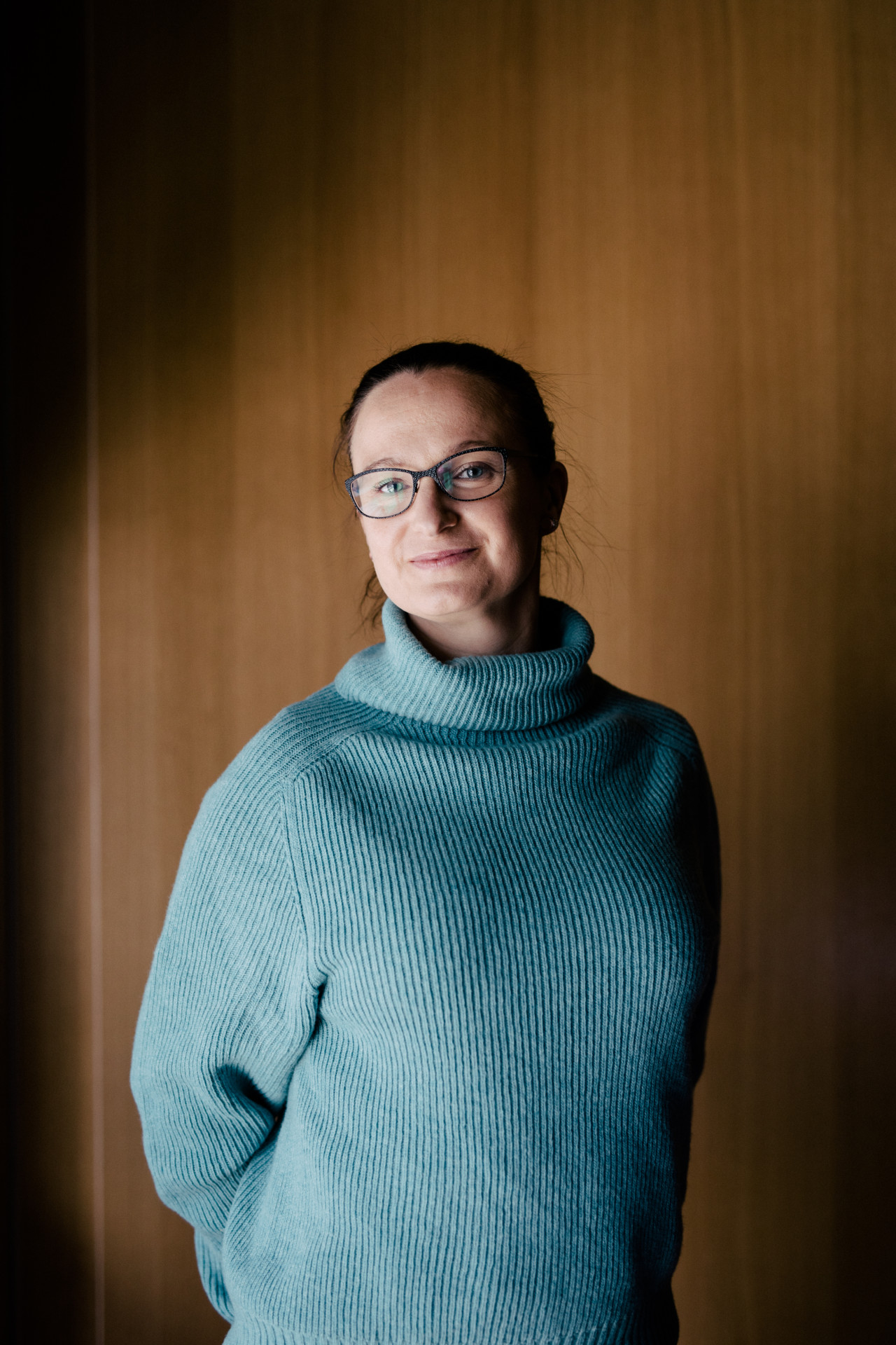 Shipitin työntekijä Nainen hymyilee kameralle vaaleansinisessä villapaidassa